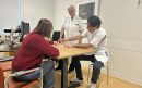 Chirurg-Edgar-Wong-Lun-Hing-en-internist-endocrinoloog-Petri-Kox-van-Gastel-geven-uitleg-aan-een-patient-liggend-beeld-scaled-aspect-ratio-800-500